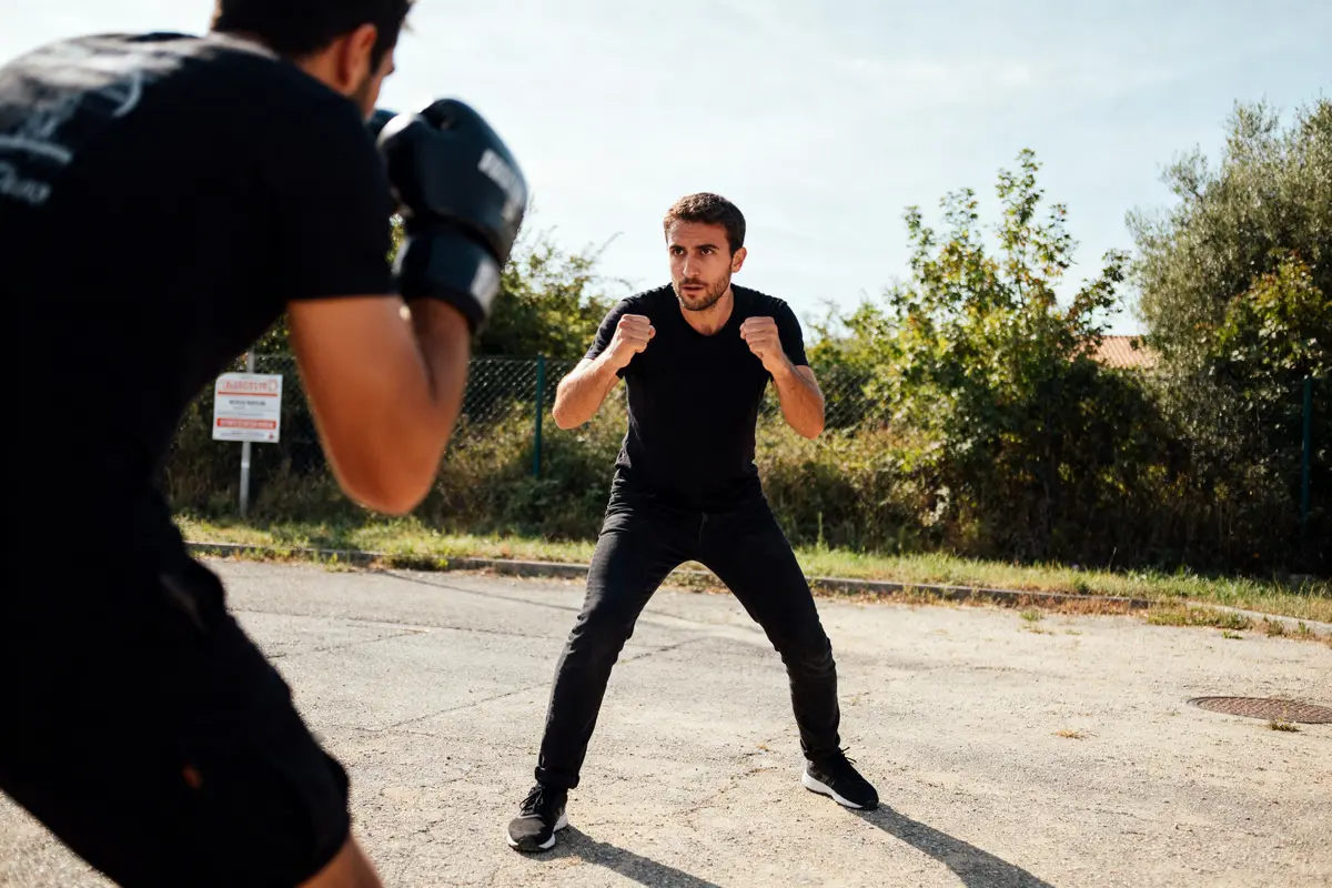 Deux hommes se préparent à s'affronter en extérieur pour un combat amical de boxe