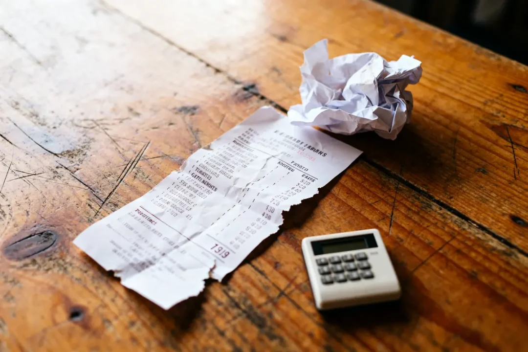 Calculateur et lmnp ticket de caisse froissé sur table en bois