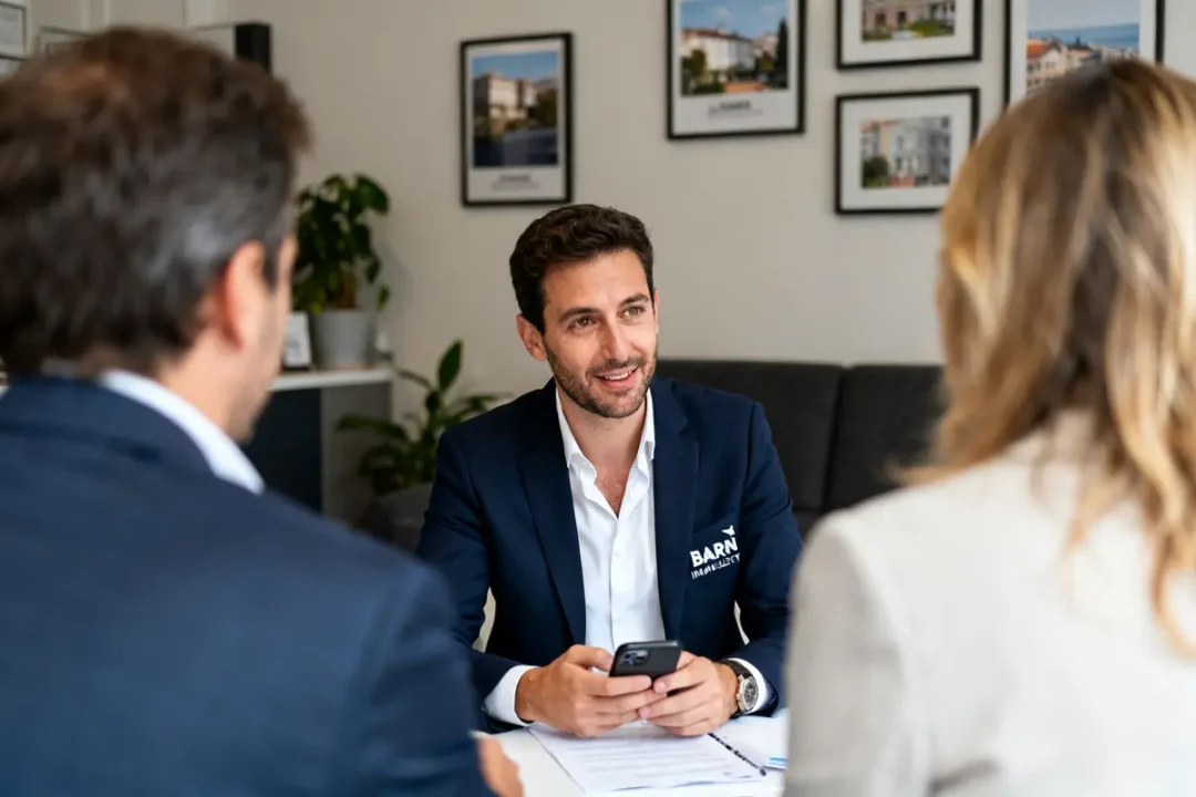 Agent Barnes Immobilier en réunion avec clients, discutant d'opportunités immobilières dans un bureau.