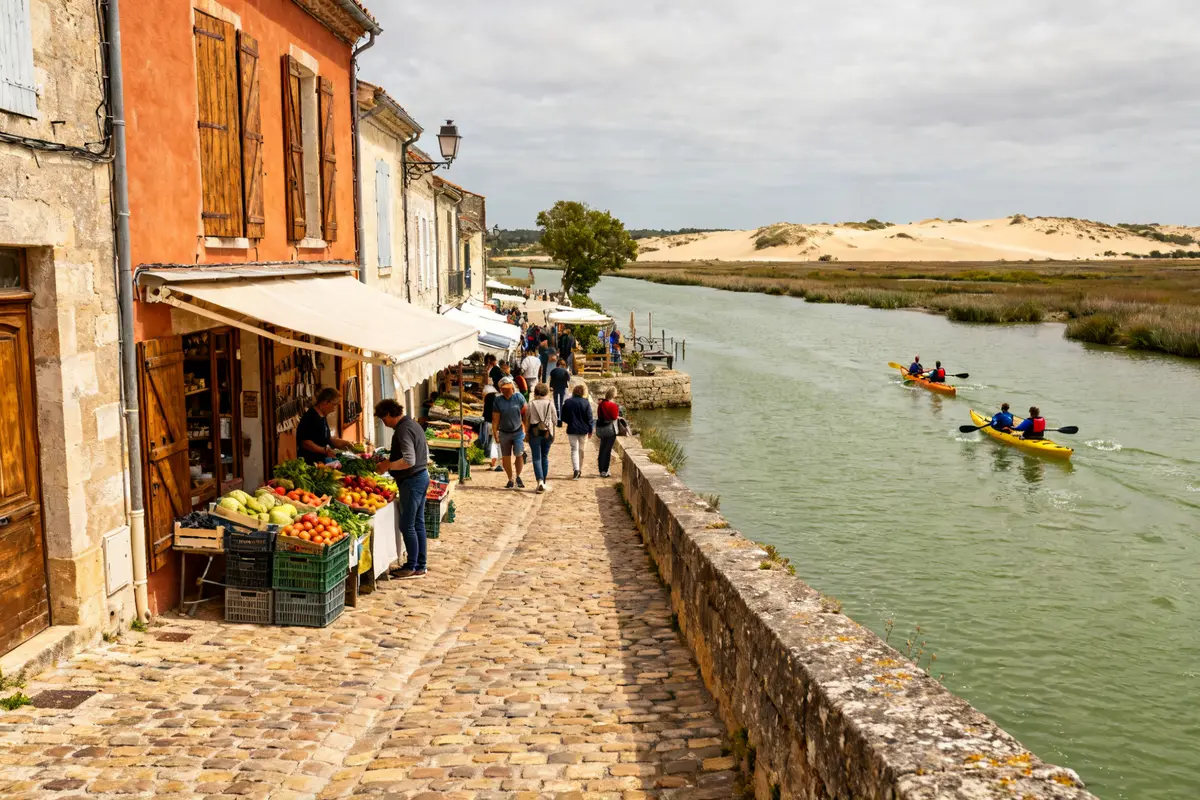 Personnes se promenant à Mornac sur Seudre près de kayaks sur le canal fleuri