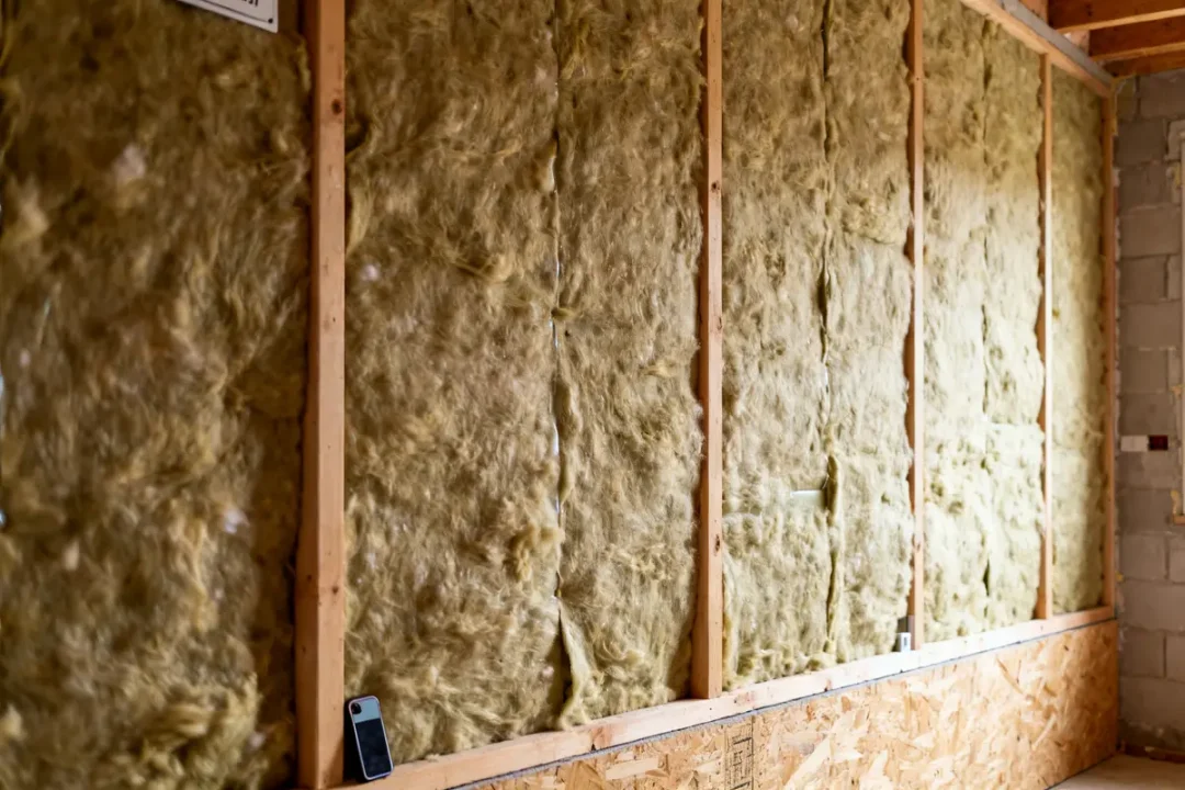 Matériaux d'isolation phonique mur intérieur installés entre montants en bois dans une pièce en construction